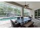 Covered outdoor dining area overlooking a pool, gazebo, and surrounding landscape at 5151 Jasmine Way, Palm Harbor, FL 34685