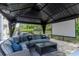 Covered outdoor gazebo with movie screen and comfortable seating area for backyard enjoyment at 5151 Jasmine Way, Palm Harbor, FL 34685