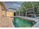 The screened pool area includes a spa and a gazebo with outdoor seating, with access to the home at 5151 Jasmine Way, Palm Harbor, FL 34685