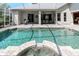 Backyard pool with attached spa and covered patio area with seating at 5151 Jasmine Way, Palm Harbor, FL 34685