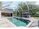 Screened-in pool with bright blue water, hot tub, and access to a large outdoor kitchen and living space at 5151 Jasmine Way, Palm Harbor, FL 34685