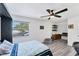 Cozy bedroom with gray wood floors, a ceiling fan, desk, and a view of the neighborhood at 5404 4Th Avenue Nw Dr, Bradenton, FL 34209