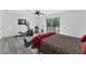 Bright bedroom featuring gray wood floors, fitness equipment, and a ceiling fan at 5404 4Th Avenue Nw Dr, Bradenton, FL 34209