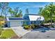 Gorgeous exterior view featuring manicured lawn, metal roof, solar panels, blue shutters, and a two car garage at 5404 4Th Avenue Nw Dr, Bradenton, FL 34209