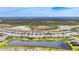 Aerial view of homes surrounding a community lake and lush trees on a sunny day at 5688 Woodland Sage Dr, Sarasota, FL 34238