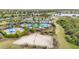Aerial view of community amenities featuring a pool, playground, clubhouse, sand volleyball court and manicured landscaping at 5688 Woodland Sage Dr, Sarasota, FL 34238