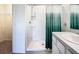 Bright bathroom featuring a walk-in shower with glass shelving, and a large single sink vanity at 5688 Woodland Sage Dr, Sarasota, FL 34238