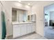 Bright bathroom featuring a dual sink vanity with white cabinets and a large mirror at 5688 Woodland Sage Dr, Sarasota, FL 34238