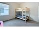 Bright bedroom featuring a bunk bed, soft carpet, and a large window at 5688 Woodland Sage Dr, Sarasota, FL 34238