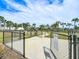 Gated community dog park with mature trees and a wash station on a sunny day at 5688 Woodland Sage Dr, Sarasota, FL 34238