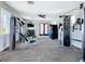 Bright gym featuring weight machines, dumbbells, flat screen TV, ceiling fan and large windows at 5688 Woodland Sage Dr, Sarasota, FL 34238