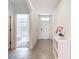 Bright hallway featuring neutral tile flooring and a view into a well-lit bedroom at 5688 Woodland Sage Dr, Sarasota, FL 34238