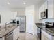 Modern kitchen with stainless steel appliances, granite countertops, and white cabinets for a sleek design at 5688 Woodland Sage Dr, Sarasota, FL 34238