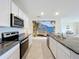 Beautiful kitchen with granite counters, stainless steel appliances, and scenic mural backsplash at 5688 Woodland Sage Dr, Sarasota, FL 34238
