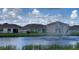 View of the community pond with a fountain surrounded by well-maintained homes under a cloudy sky at 5688 Woodland Sage Dr, Sarasota, FL 34238