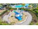 Overhead view of a community splash pad with water features and lounge chairs, surrounded by lush greenery at 5688 Woodland Sage Dr, Sarasota, FL 34238