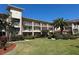Beautiful condo building with multiple balconies, lush landscaping, and well-maintained lawn at 6501 Stone River Rd # 209, Bradenton, FL 34203