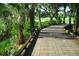 Charming golf cart path surrounded by lush greenery, palm trees, and providing a scenic route through the course at 6501 Stone River Rd # 209, Bradenton, FL 34203