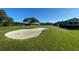 Golf course with sand trap, clubhouse, golf carts and manicured grass, showing a great amenity at 6501 Stone River Rd # 209, Bradenton, FL 34203