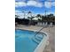 Community pool featuring lounge chairs, a hot tub, and convenient access steps for relaxation and recreation at 6501 Stone River Rd # 209, Bradenton, FL 34203