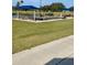 Outdoor community pool area featuring lounge chairs, tables, and shaded seating under blue canopies at 6501 Stone River Rd # 209, Bradenton, FL 34203