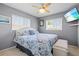 Light-filled bedroom featuring a decorative ceiling fan, two windows, and a mounted television at 7 Braden Castle Dr, Bradenton, FL 34208