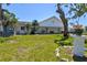 White community center with lawn, shade trees, flowers, and benches, offers a place for residents to relax and socialize at 7 Braden Castle Dr, Bradenton, FL 34208