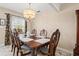 Traditional dining room featuring an ornate chandelier, window views, and carved wooden chairs at 7 Braden Castle Dr, Bradenton, FL 34208