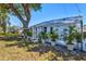 Charming home exterior with a well-manicured lawn, lush tropical plants, and golf cart at 7 Braden Castle Dr, Bradenton, FL 34208