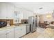 Well-lit kitchen featuring stainless steel appliances, white cabinets, and a view of the dining area at 7 Braden Castle Dr, Bradenton, FL 34208