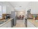 Bright kitchen featuring stainless steel appliances, white cabinetry, and a view towards the dining space at 7 Braden Castle Dr, Bradenton, FL 34208