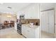 Kitchen with white cabinets and stainless steel appliances, adjacent to a dining area at 7 Braden Castle Dr, Bradenton, FL 34208