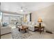 Bright living room featuring neutral couches, a coffee table, and a view of the adjacent sunroom at 7 Braden Castle Dr, Bradenton, FL 34208