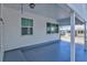 Covered porch area featuring painted floors and ample natural light from the surrounding windows at 7 Braden Castle Dr, Bradenton, FL 34208