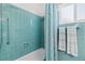 Shower with sleek blue tiles and a grab bar, complemented by coordinated turquoise towels at 7 Braden Castle Dr, Bradenton, FL 34208