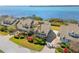 Aerial view of waterfront townhome with lush landscaping, brick paver driveway, and stunning ocean views at 71 Tidy Island Blvd, Bradenton, FL 34210