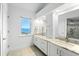 Bathroom featuring double sinks with granite countertops and walk in shower with glass door and water view at 71 Tidy Island Blvd, Bradenton, FL 34210