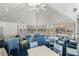 Beautifully decorated clubhouse with multiple tables, blue accent chairs, and stunning cathedral ceiling at 71 Tidy Island Blvd, Bradenton, FL 34210