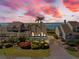 Beautiful exterior of a multi-story home with lush landscaping, palm trees, and a colorful sky at sunset at 71 Tidy Island Blvd, Bradenton, FL 34210