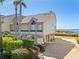 Coastal townhome features lush landscaping, brick paver driveway, under-house garage and desirable beachside location at 71 Tidy Island Blvd, Bradenton, FL 34210