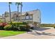 Coastal townhome features lush landscaping, brick paver driveway, and desirable under-house garage and parking at 71 Tidy Island Blvd, Bradenton, FL 34210