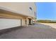 Under-house garage with brick pillars and adjacent parking for a coastal townhome, steps to beach at 71 Tidy Island Blvd, Bradenton, FL 34210