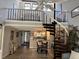 View of dining area with spiral staircase leading to loft area and kitchen with stainless steel appliances in background at 7520 4Th W Ave # 1, Bradenton, FL 34209