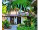 Charming home with a walkway lined with lush plants, leading to the front door underneath a tree at 7520 4Th W Ave # 1, Bradenton, FL 34209