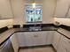 Kitchen sink features black countertops, window, and white cabinets at 7520 4Th W Ave # 1, Bradenton, FL 34209