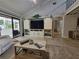 Relaxing living room featuring neutral colors, a sliding glass door, vaulted ceiling, and a custom entertainment center at 7520 4Th W Ave # 1, Bradenton, FL 34209