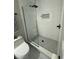 Stylish shower with frameless glass, pebble floor, and white subway tile surround at 7520 4Th W Ave # 1, Bradenton, FL 34209