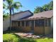 Enclosed sunroom with screened windows overlooks a green lawn and tropical landscaping at 7520 4Th W Ave # 1, Bradenton, FL 34209
