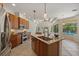 Stylish kitchen with a center island, granite countertops, and stainless steel appliances overlooking the pool at 7618 Broomsedge Ct, Lakewood Ranch, FL 34202