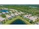 Aerial view showcases homes with screened pools along a lake in a well-planned community at 7664 Camminare Dr, Sarasota, FL 34238